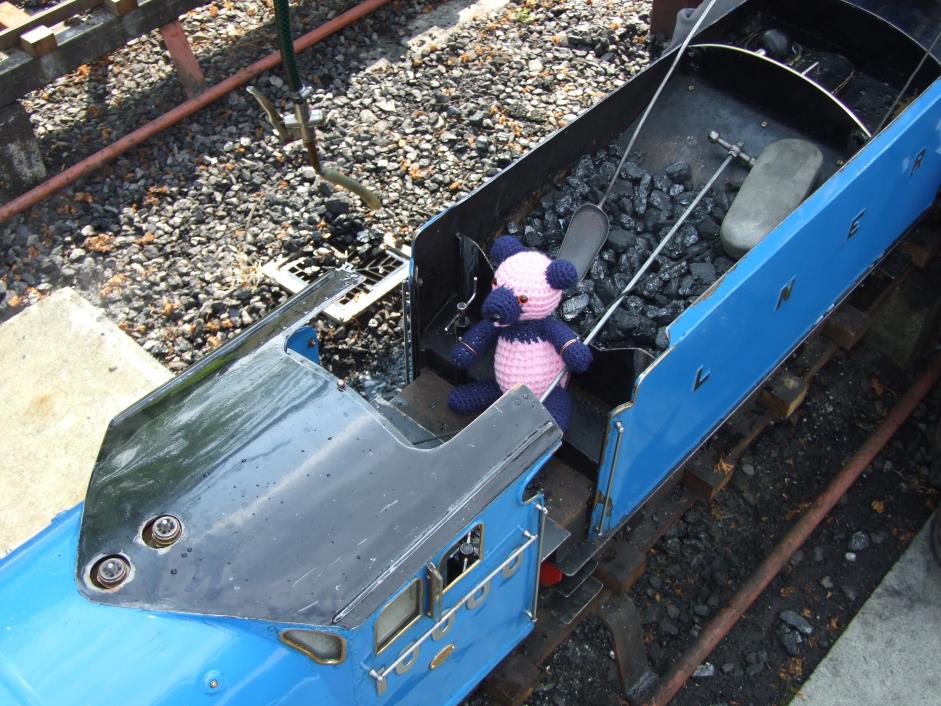 Sam in the cab of a miniature train